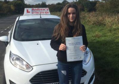 Ceri standing by andrew's driving school car with pass certificate.