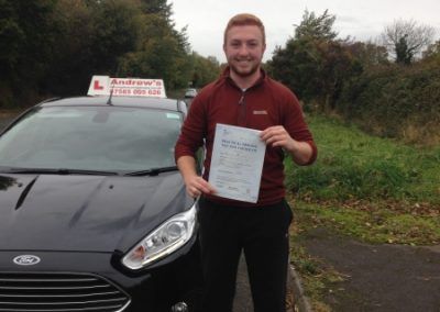Markus standing with driving test pass certificate