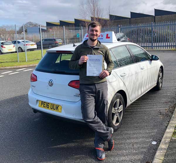 Adam at  Bangor Test Centre with a driving test pass certificate.