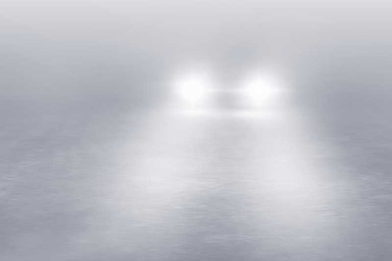 Oncoming car in fog with fog lights on