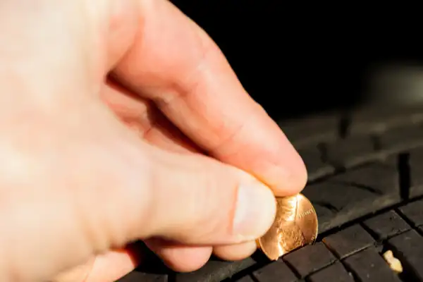 Tread Depth Coin Check Checking tyre tread with a coin close up image