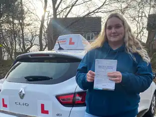 Young Lady with driving test pass certificate outside Wrexham Driving Test Centre