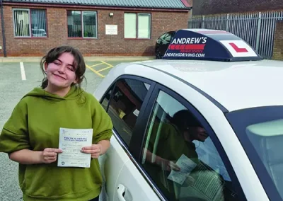 Young Lady outside Rhyl Driving Test Centre holding a pass certificate