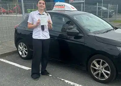 Young lady with her driving test pass certificate, standing by Geraints car
