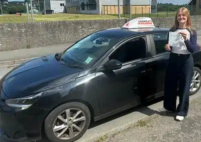 Showing off a driving test pass certificate on the side of the road