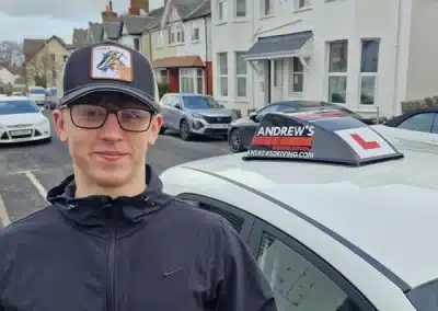 Successful driving test pass for Bryn at Rhyl Driving Test Centre with Andrew's Driving School: student pictured with branded tuition car after passing his test.