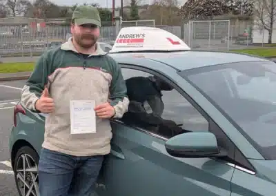 Dill from Colwyn Bay holding his pass certificate in Bangor Driving Test Centre Car Park