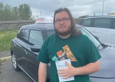 Jordan from Old Colwyn holding pass certificate after first-time driving test success in Rhyl