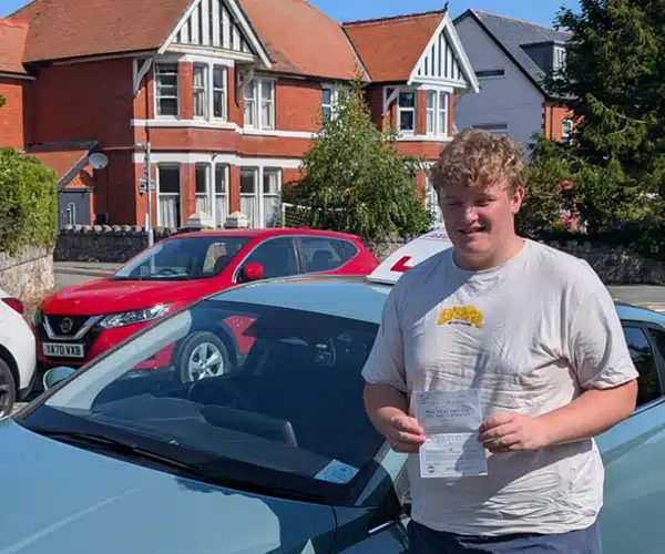 Henry Thornton celebrates passing his driving test in Rhyl with instructor Jack from Andrew's Driving School.