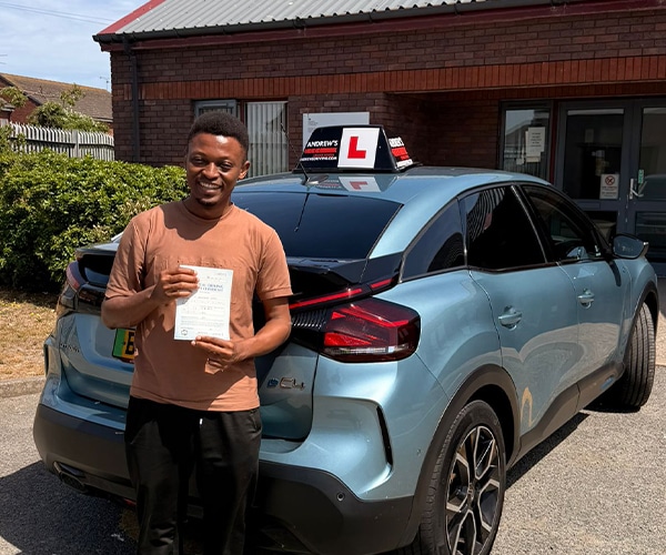 Peter Ukah celebrates passing his driving test in Rhyl with instructor Abdullah from Andrew's Driving School.