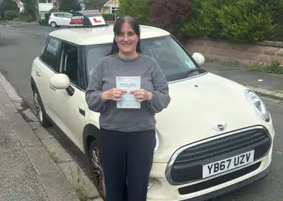 Tracy holds her driving test pass certificate in front of Jimmy’s learner car after passing at Rhyl Driving Test Centre.