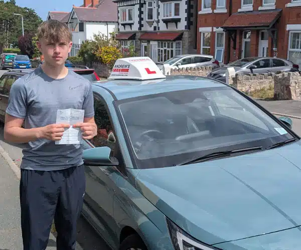 Tyler Dakin celebrates passing his driving test first time in Rhyl with instructor Jack from Andrew's Driving School.