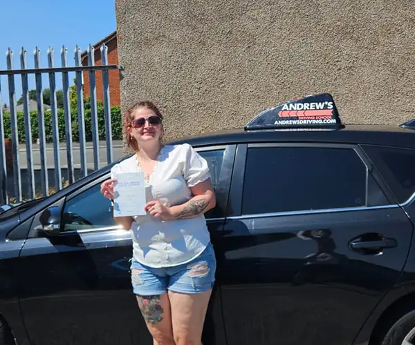 Murron Snape holding her driving test pass certificate at Rhyl Driving Test Centre after passing first time with instructor Darren from Andrew's Driving School.