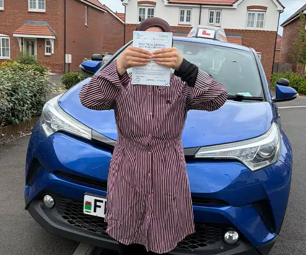 Learner driver celebrates passing an automatic driving test in Rhyl with instructor Fiona from Andrew's Driving School.