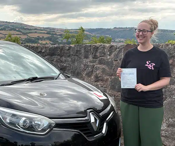 Heidi celebrating a driving test pass with Andrew's Driving School.