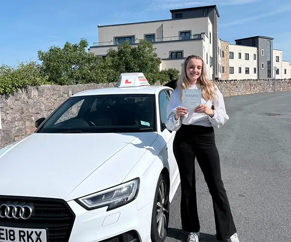 Laura Openshaw after passing her driving test in Rhyl beside instructor Marcus’s Audi.
