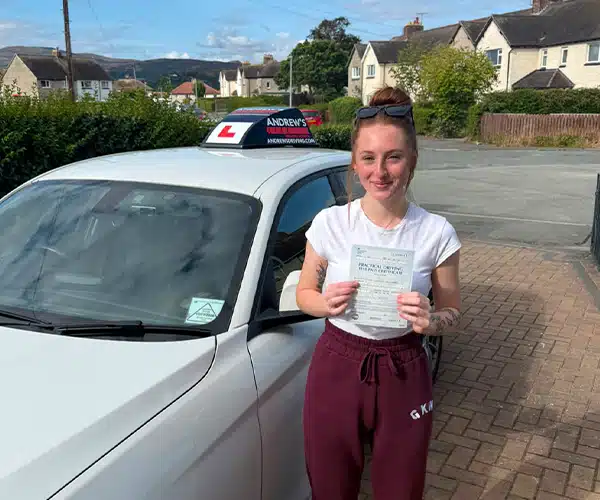 Tasha with her pass certificate standing by Ben's BMW tuition car.
