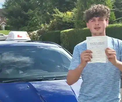 Dyfed standing by Craig's car  with his pass certificate