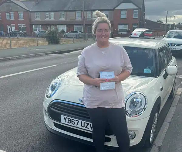 Leah after passing her driving test in Rhyl beside her instructor’s car