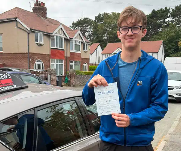 Lewis celebrating a driving test pass in Rhyl with Andrew's Driving School.