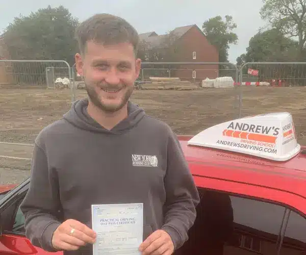 Dylan beside Adrian’s Andrew’s Driving School Suzuki Swift after passing his driving test