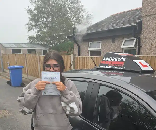 Erin honding her pass certificate by Kim's Andrew's Driving School car after passing in Rhyl with zero minors