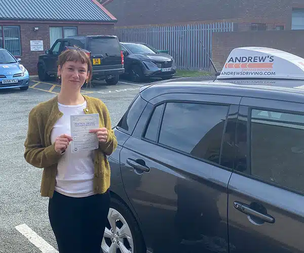 Grace McLaughlin after passing her driving test in Rhyl beside her instructor Andy Kirkham's Suzuki Swift