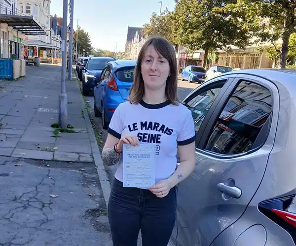 
Emily holding her driving test pass certificate standing by Barry's automatic Corsa after passing first time in Rhyl with zero faults.