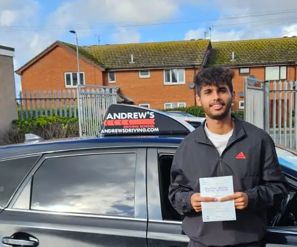Joyal beside instructor Darren’s Toyota Auris at Rhyl Driving Test Centre after passing his driving test first time.
