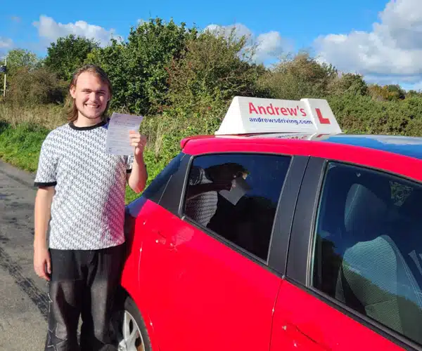 Ryan stood next to Claire's red Yaris after passing his auto driving test first time in Bangor with zero minors.