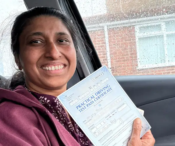 Shyny Philip from Colwyn Bay celebrating her first-time automatic driving test pass in Rhyl after lessons with instructor Ryan McCarley at Andrew's Driving School.